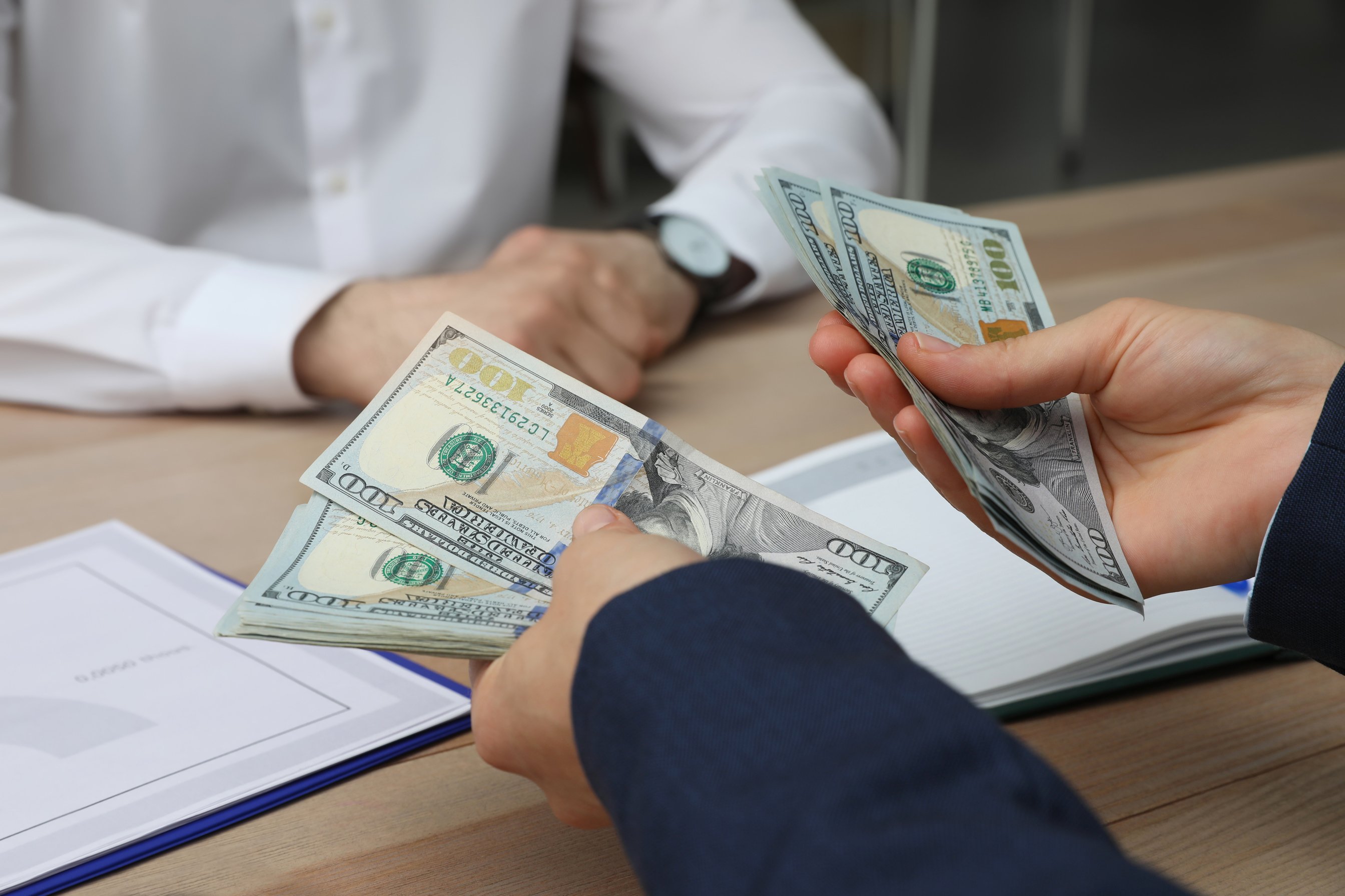 Cashier Counting Money at Desk in Bank, Closeup